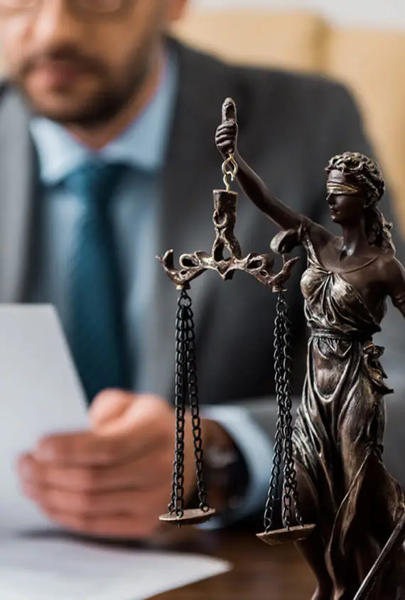 close up view of lady justice statue and lawyer wo RE8YGXA